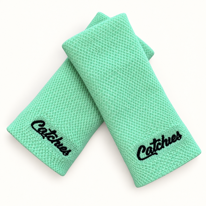 Green Goals wristbands in crossed arrangement on ivory background