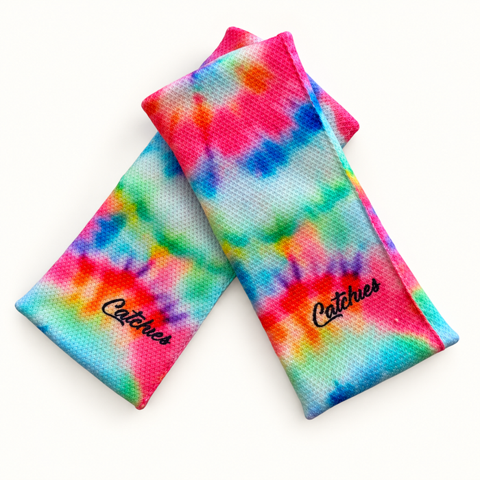 Tie Dye Turns wristbands in crossed arrangement on ivory background